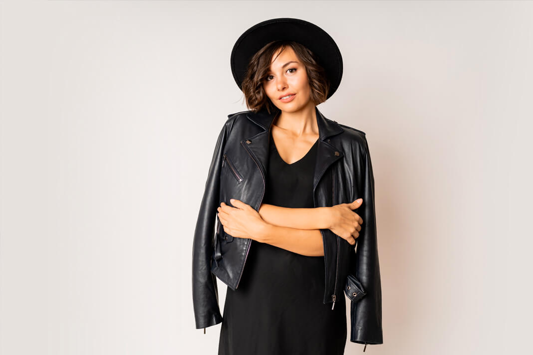 Woman with curly hair wearing a hat and jacket
